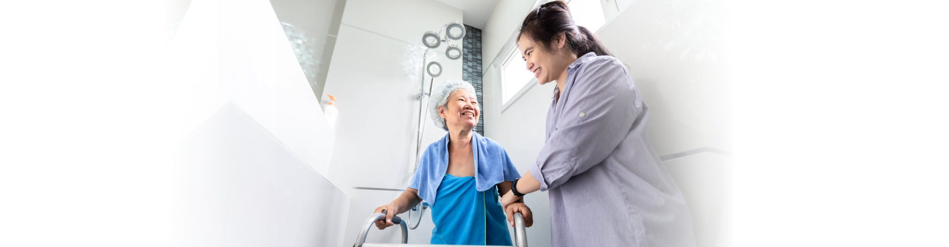 caregiver assisting senior woman in bathroom